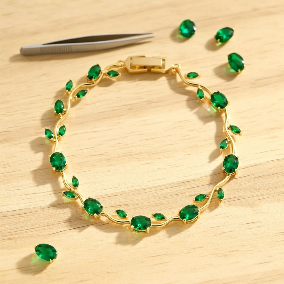 Green tulip bracelet laid flat on a pale craft bench with loose green stones and tweezers