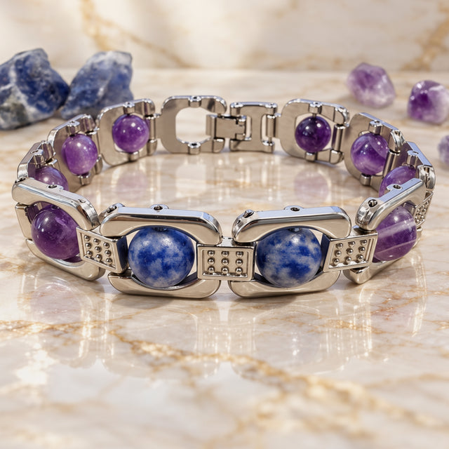 Silver Aquarius zodiac bracelet on a cream stone surface with raw stones