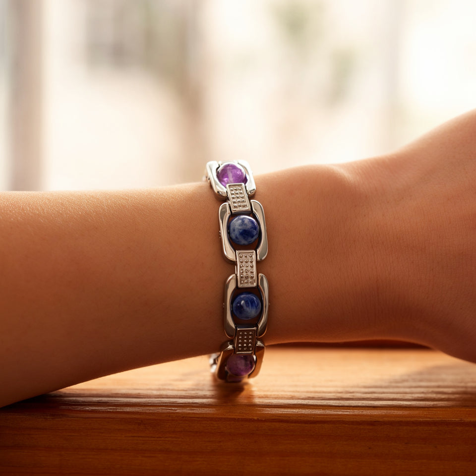 Silver Aquarius zodiac bracelet worn on a woman's wrist by a sunlit window