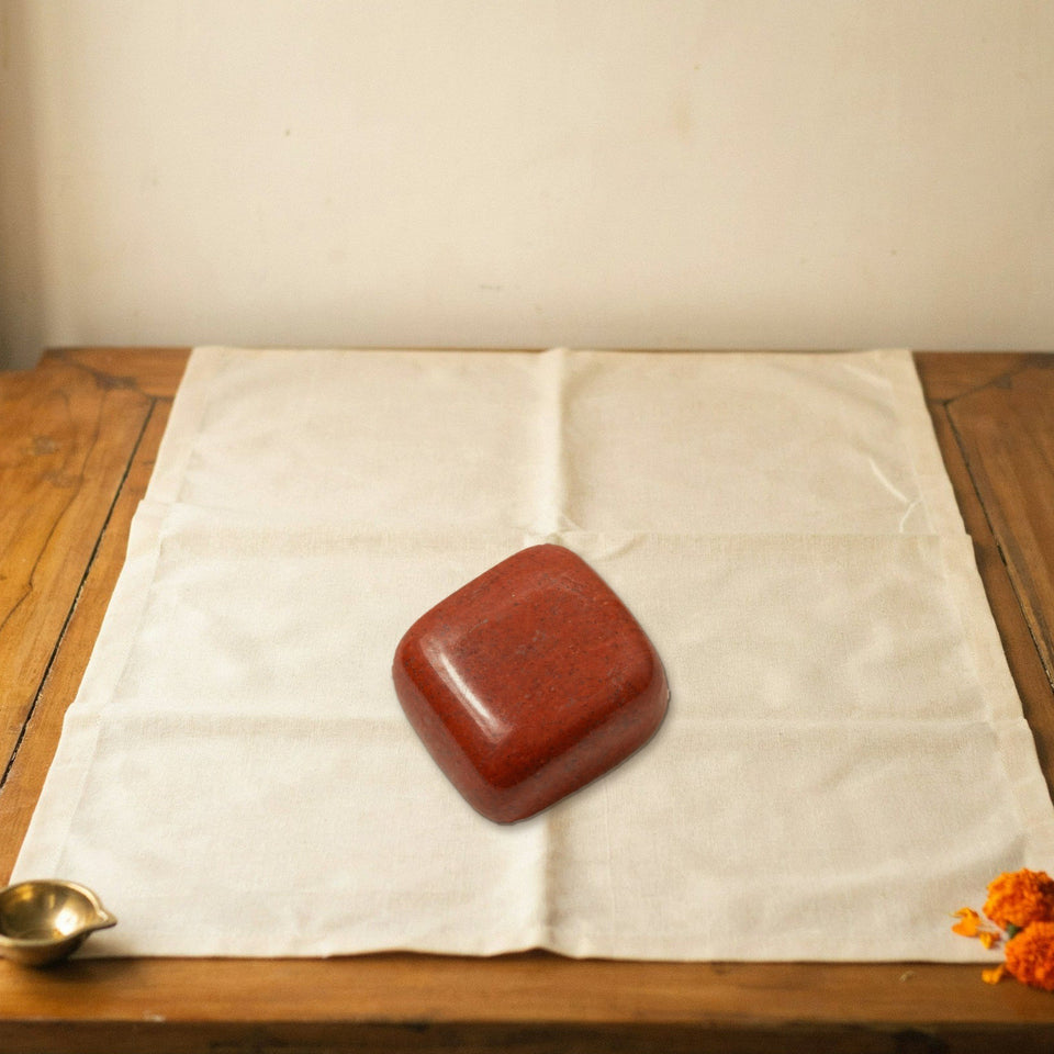red jasper tumble placed on a shelf