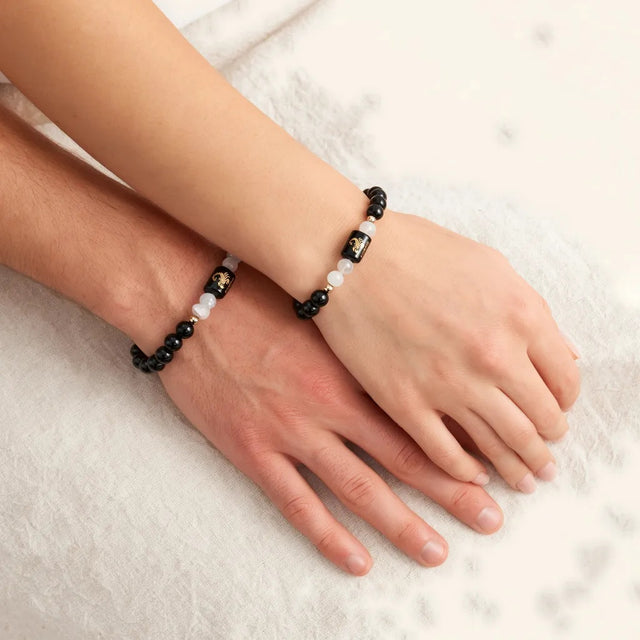 A man's and a woman's wrist each wearing the Scorpio bracelet