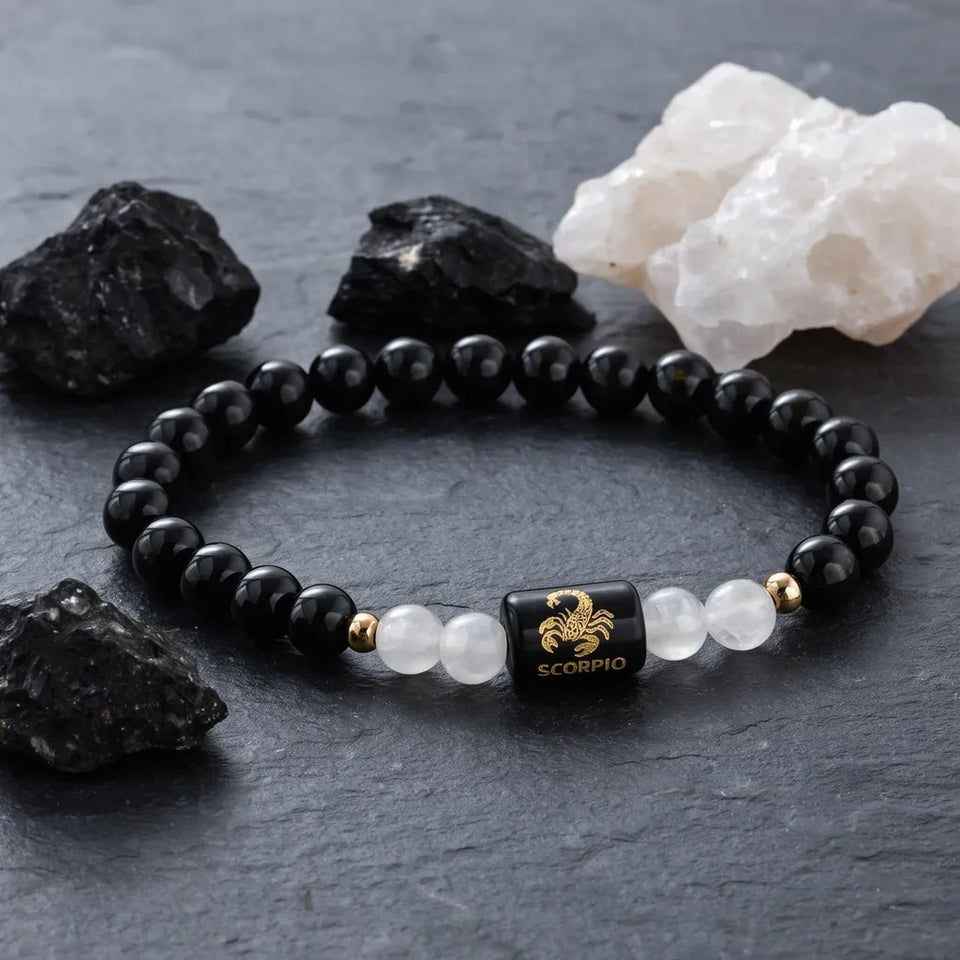 Scorpio zodiac bracelet beside raw black obsidian and milky quartz
