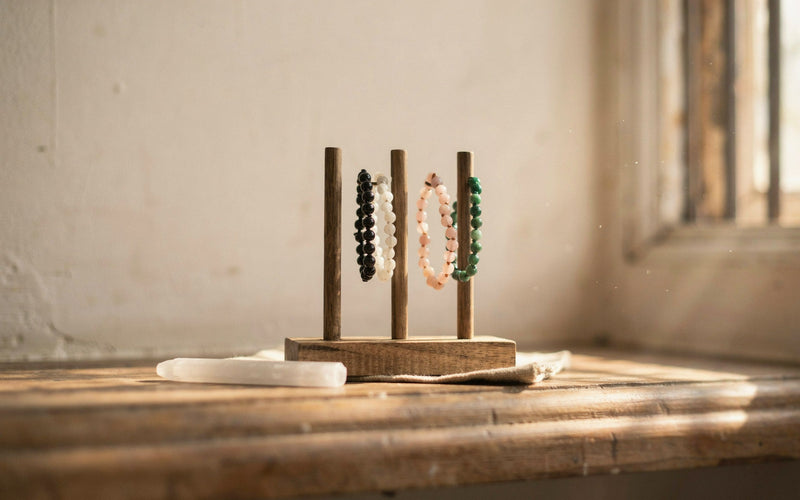 Stone bracelets hanging on a wooden bracelet stand