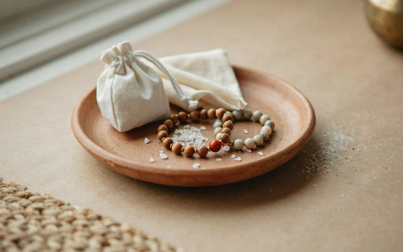 A small white cotton pouch and a soft polishing cloth beside two