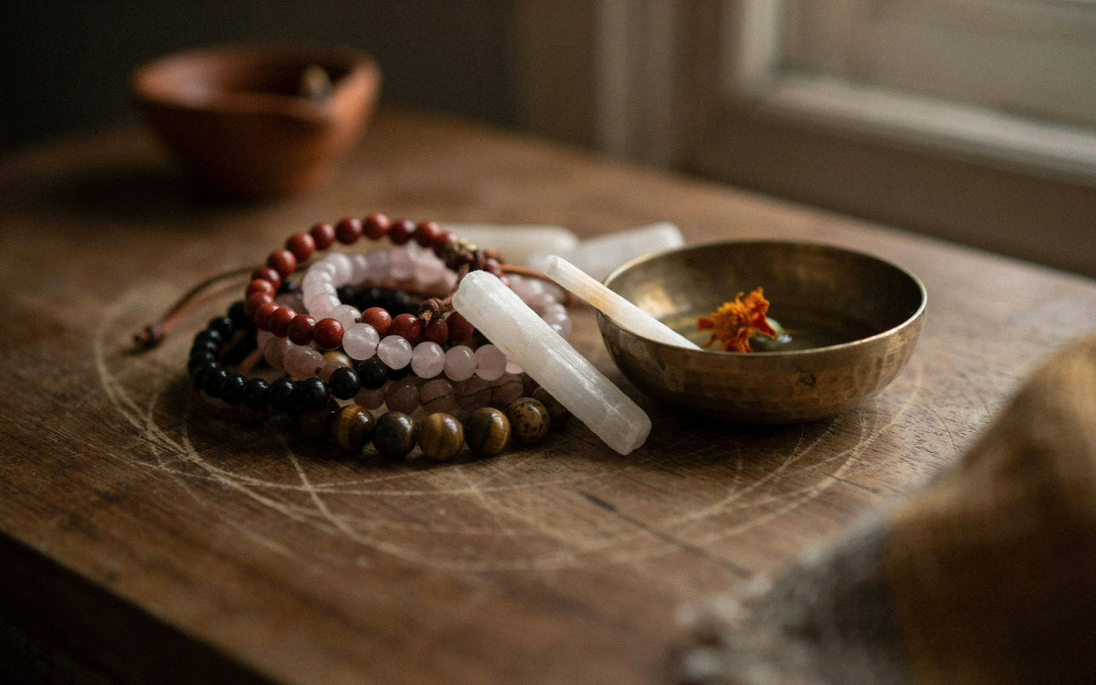Assorted stone bracelets with a small selenite stick and a brass bowl
