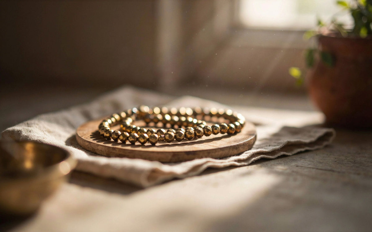 Pyrite money bracelet with golden metallic beads on a wooden tray