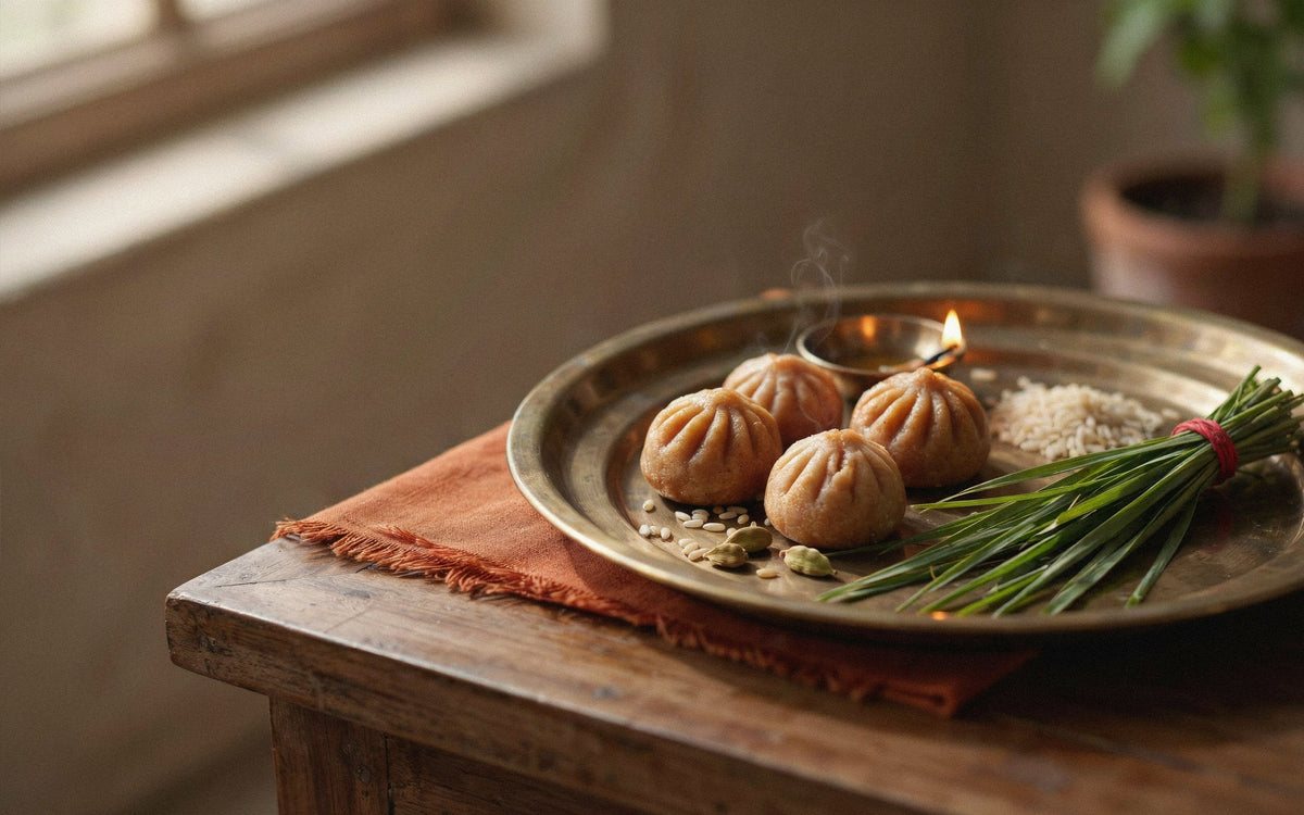 Ganesh Chaturthi offering of modak and durva grass in a brass plate
