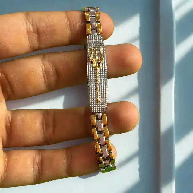 Shiva's Trishul dual tone bracelet held in hand