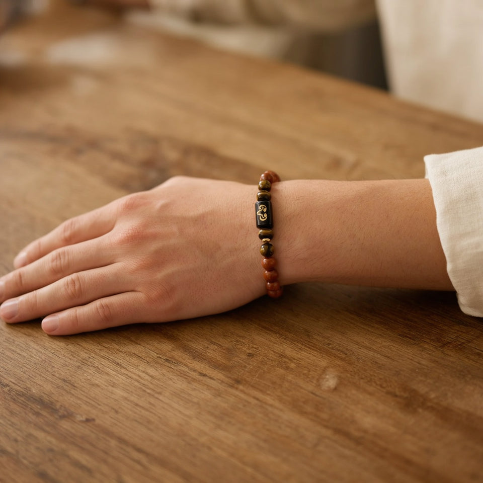 Aries zodiac bracelet worn on a wrist resting on a wooden table