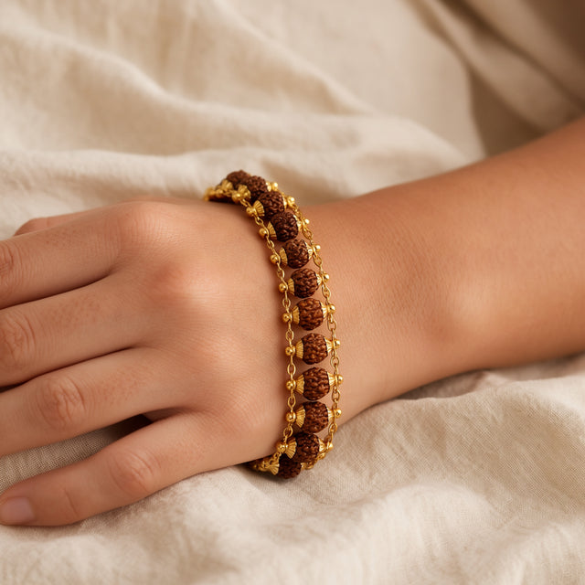 Gold plated 5 mukhi rudraksha bracelet fitted snugly on a woman's wrist