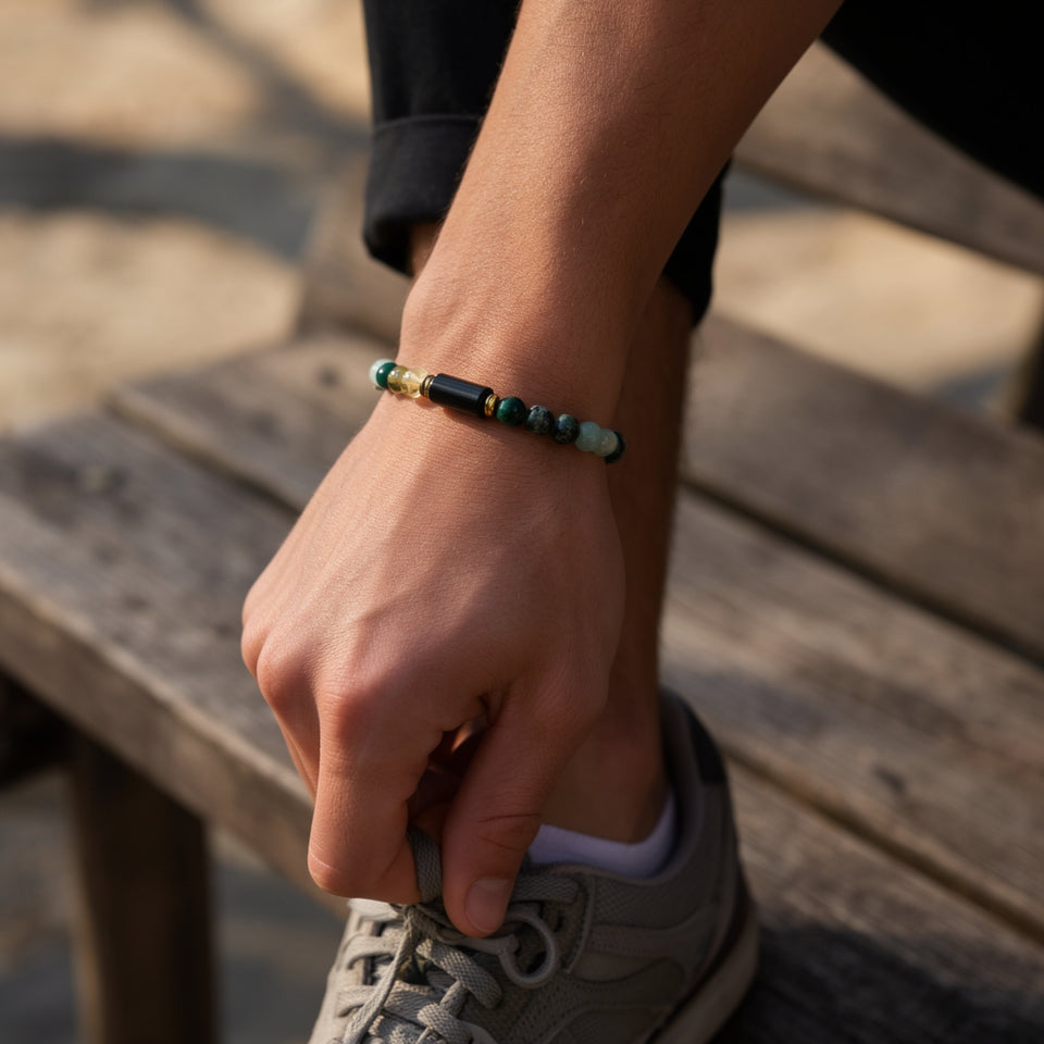 Numero 5 bracelet on a man's wrist as he ties a shoelace