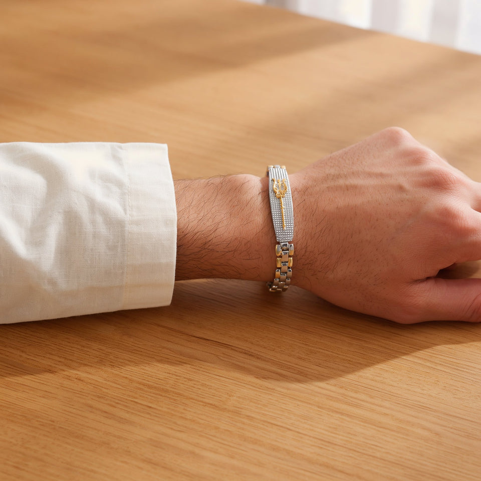 Man in a cream kurta wearing a dual tone Trishul bracelet