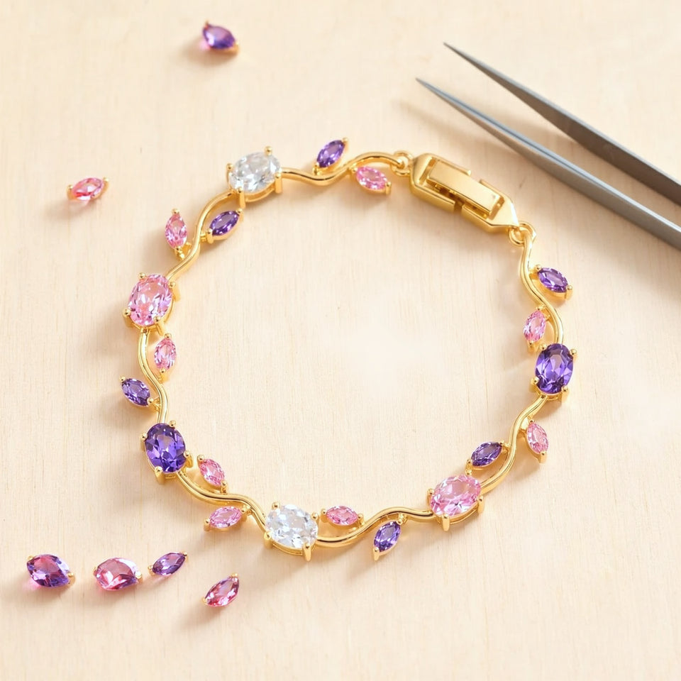 Pink and purple tulip bracelet laid flat on a pale craft bench with loose stones and tweezers