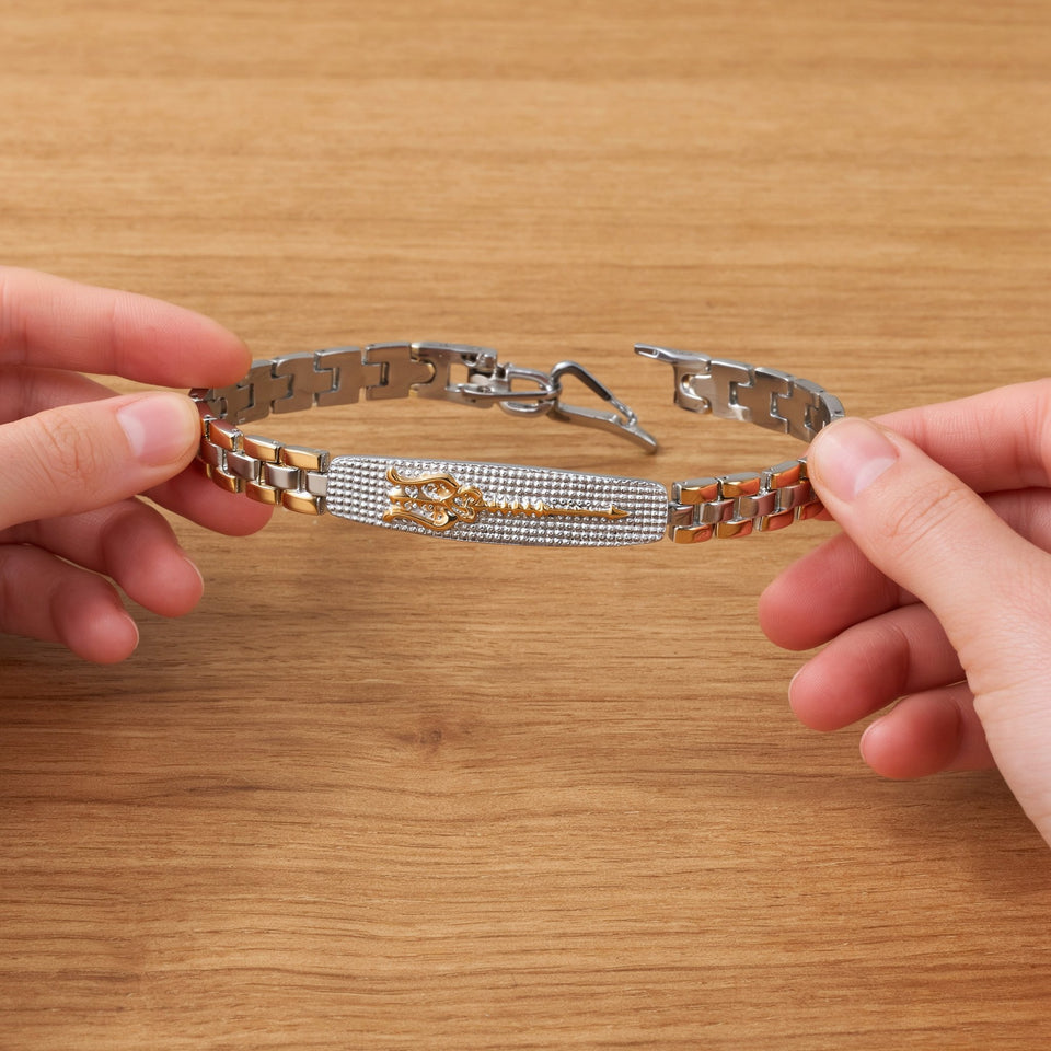 Hands holding a dual tone Trishul bracelet with the clasp open