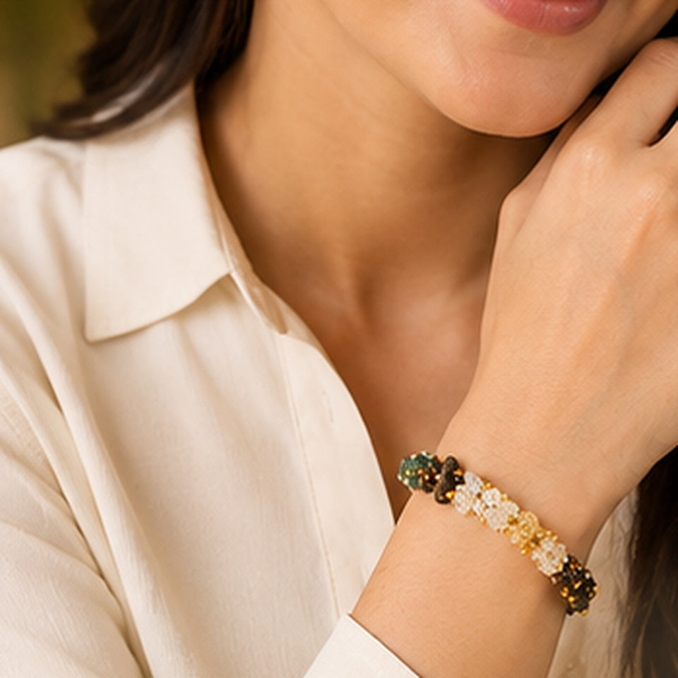 Woman in a cream shirt wearing the Dhan Yog gemstone chip bracelet