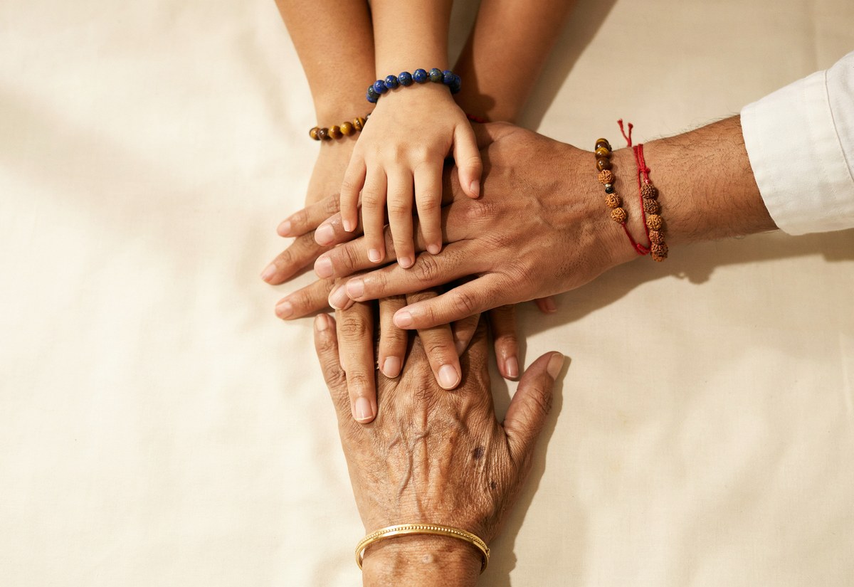 Family hands stacked wearing bracelets