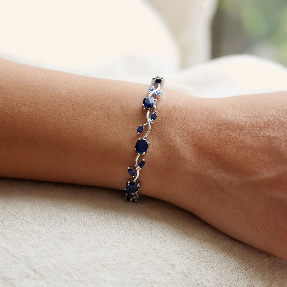Woman's wrist wearing a silver-tone blue tulip bracelet