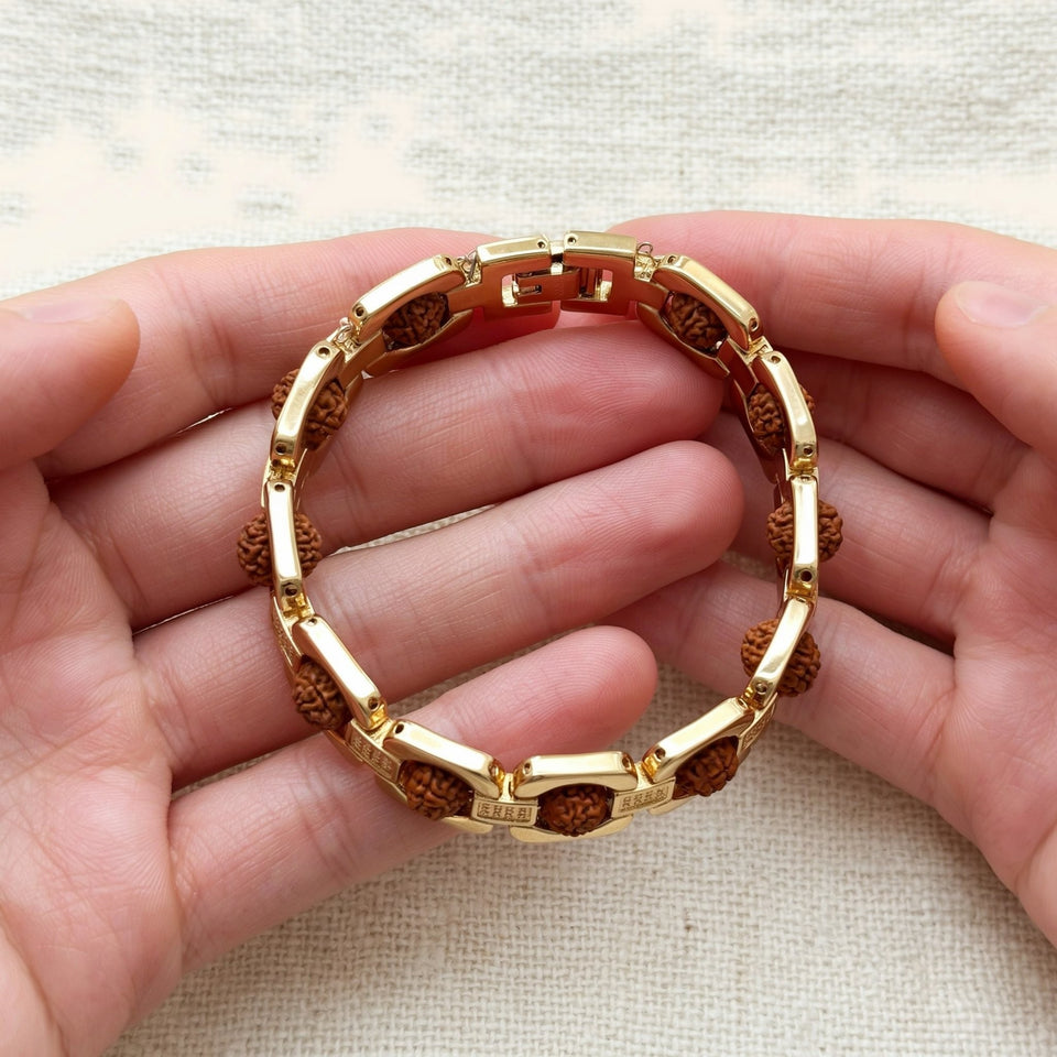 Two hands holding a gold link Rudraksha bracelet open with its clasp at the top