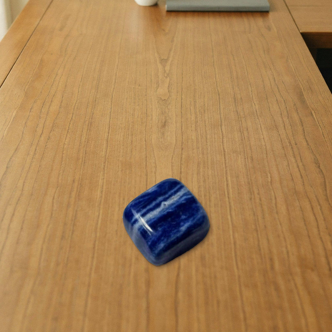 natural sodalite tumble placed on a wooden desk