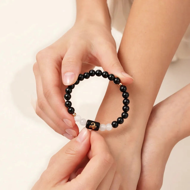 Sliding the Scorpio zodiac bracelet over the hand