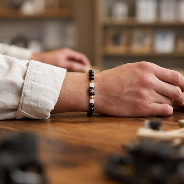 Scorpio zodiac bracelet on a man's wrist at a shop counter