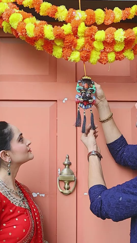 Couple hanging a Kirtimukh above the main door