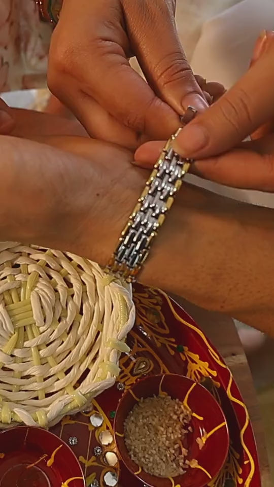 Om steel bracelet tied on the wrist over a Diwali thali