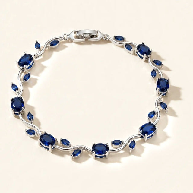 Blue tulip bracelet with silver tone vine and deep blue stones, full view